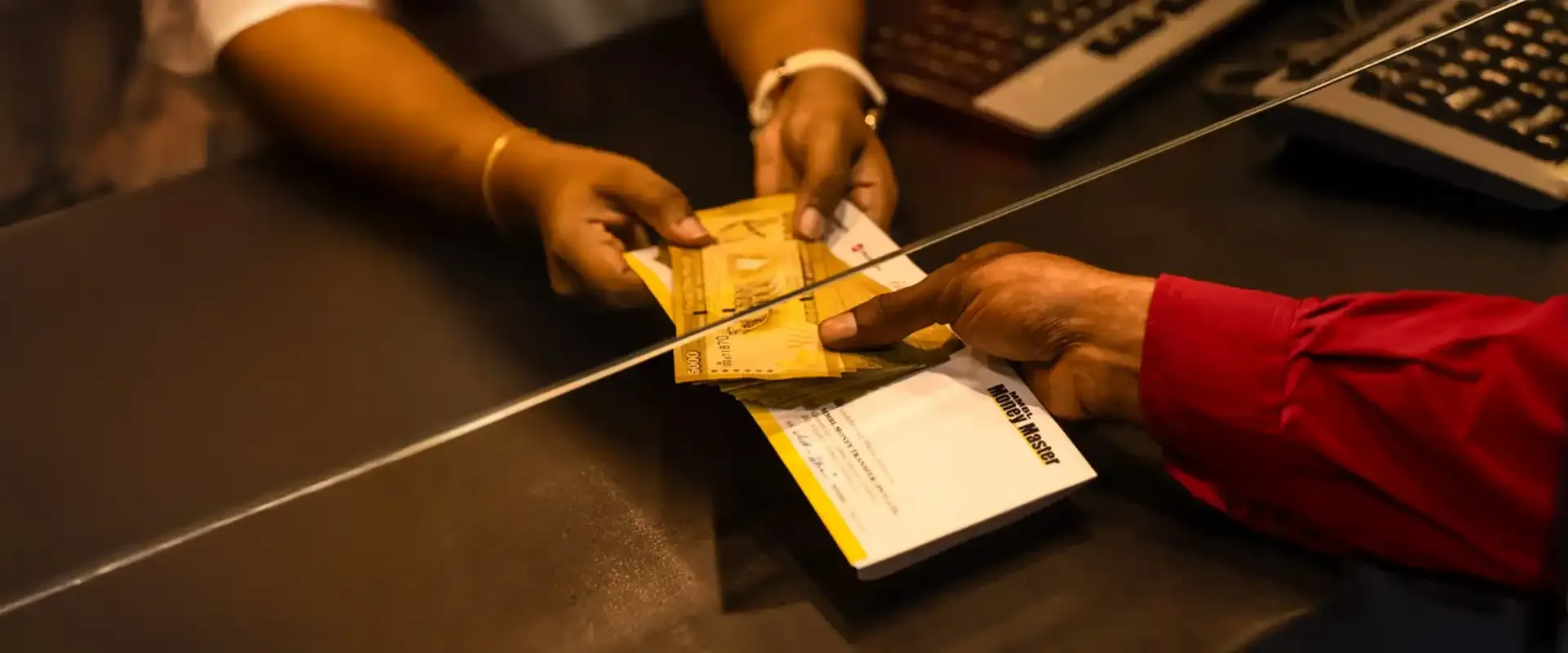 Close-up of hands as two people exchange cash during a transaction
